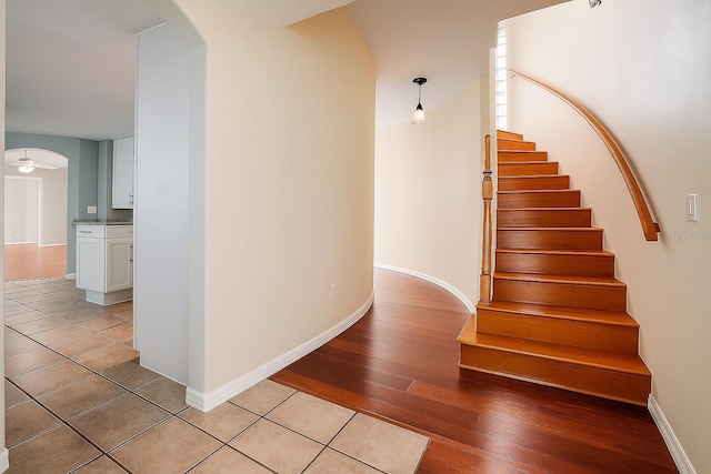 357 Fairway Pointe Cir, Orlando, FL 32828 - stairway featuring arched walkways, wood-type flooring, and baseboards