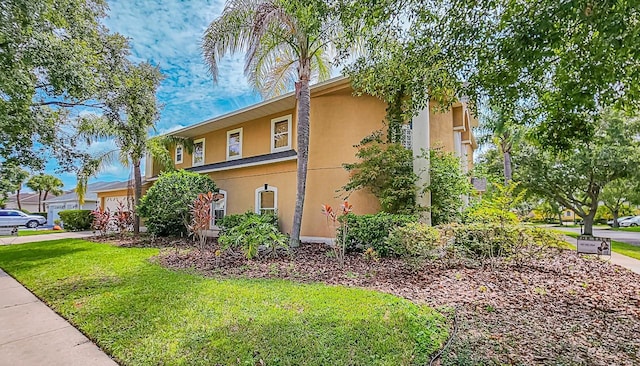 357 Fairway Pointe Cir, Orlando, FL 32828 - view of side of home featuring stucco siding and a yard