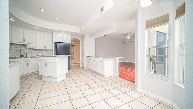 357 Fairway Pointe Cir, Orlando, FL 32828 - kitchen with a ceiling fan, arched walkways, light tile patterned flooring, tasteful backsplash, and a kitchen island