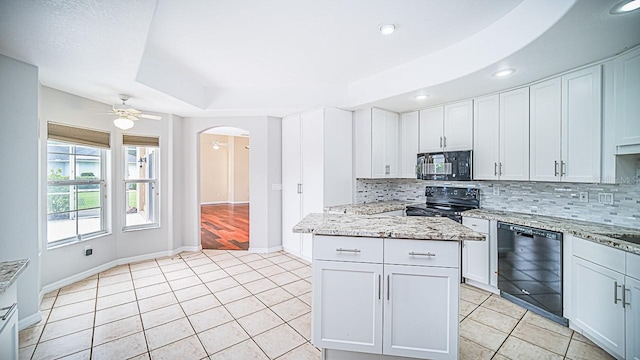 357 Fairway Pointe Cir, Orlando, FL 32828 - kitchen featuring black appliances, arched walkways, backsplash, light tile patterned floors, and recessed lighting
