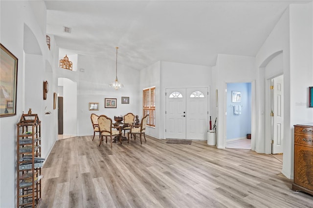 468 Alinole Loop, Lake Mary, FL 32746 - entrance foyer with high vaulted ceiling, arched walkways, light wood-style floors, a chandelier, and baseboards