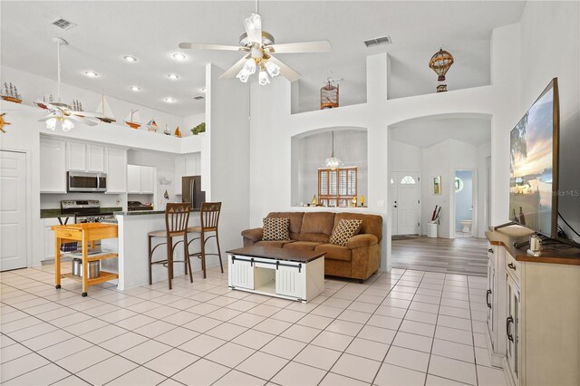 468 Alinole Loop, Lake Mary, FL 32746 - living area featuring ceiling fan, a high ceiling, arched walkways, and light tile patterned flooring