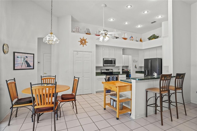 468 Alinole Loop, Lake Mary, FL 32746 - kitchen featuring appliances with stainless steel finishes, a high ceiling, a peninsula, recessed lighting, and white cabinets
