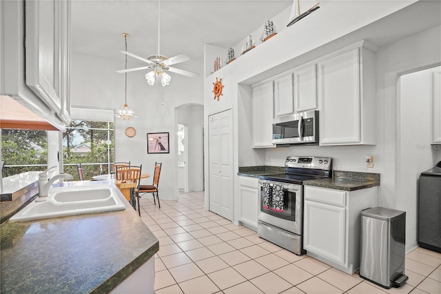 468 Alinole Loop, Lake Mary, FL 32746 - kitchen with stainless steel appliances, a sink, ceiling fan, light tile patterned flooring, and high vaulted ceiling