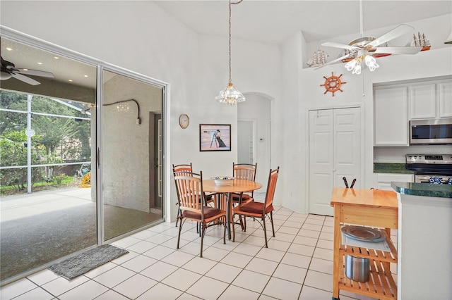 468 Alinole Loop, Lake Mary, FL 32746 - dining area with a ceiling fan, light tile patterned floors, arched walkways, and a towering ceiling
