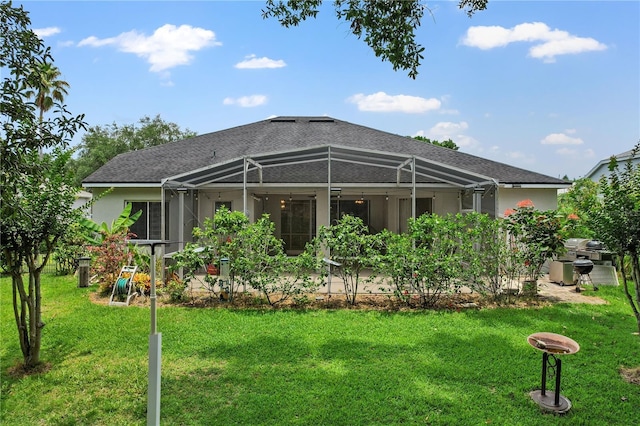 468 Alinole Loop, Lake Mary, FL 32746 - rear view of property with glass enclosure, a lawn, stucco siding, and a shingled roof