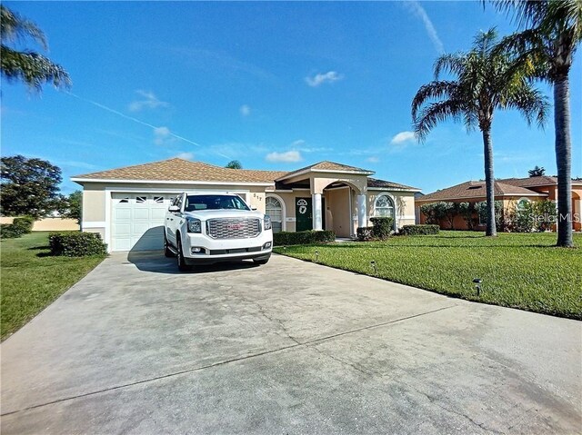 517 Westwind Dr, Davenport, FL 33896 - view of front of home featuring concrete driveway, a front lawn, stucco siding, and an attached garage