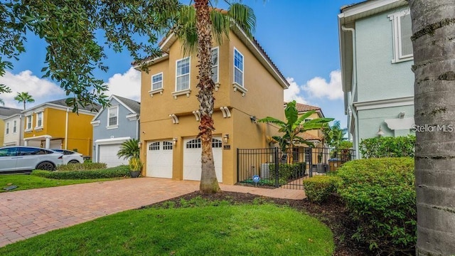 7411 Excitement Dr, Reunion, FL 34747 - view of front facade with stucco siding, decorative driveway, and an attached garage