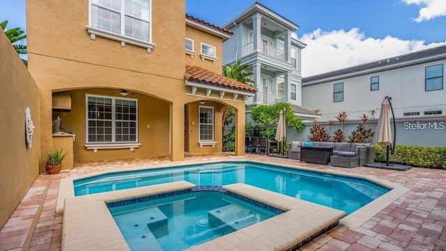 7411 Excitement Dr, Reunion, FL 34747 - back of property featuring stucco siding, a tiled roof, an outdoor hangout area, a pool with connected hot tub, and a patio area