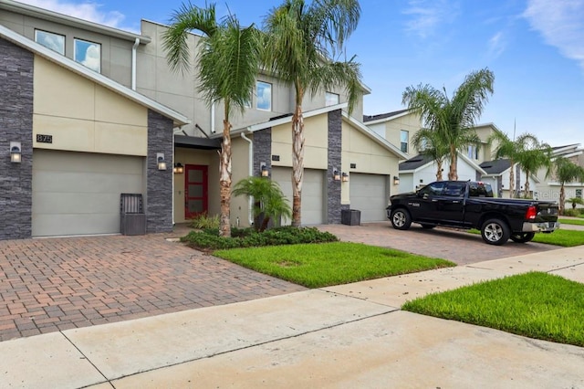 877 Ocean Course Ave, Davenport, FL 33896 - view of front of house with decorative driveway, stone siding, and stucco siding