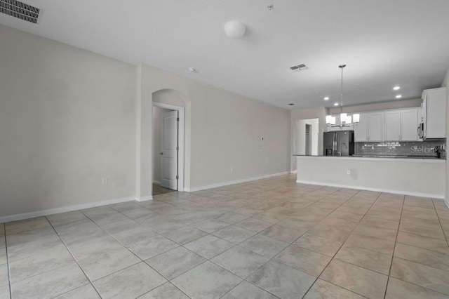 877 Ocean Course Ave, Davenport, FL 33896 - unfurnished living room with recessed lighting, arched walkways, light tile patterned floors, a chandelier, and baseboards