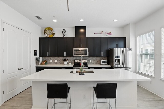 439 Windmill Palm Cir, Altamonte Springs, FL 32701 - kitchen with stainless steel appliances, a sink, tasteful backsplash, an island with sink, and recessed lighting