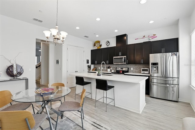 439 Windmill Palm Cir, Altamonte Springs, FL 32701 - kitchen with appliances with stainless steel finishes, light countertops, an island with sink, a sink, and a chandelier