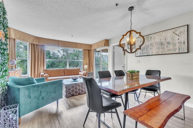6337 Parc Corniche Dr Unit 2312, Orlando, FL 32821 - dining room featuring wood finished floors, a chandelier, plenty of natural light, and a textured ceiling