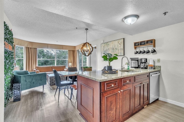 6337 Parc Corniche Dr Unit 2312, Orlando, FL 32821 - kitchen with stainless steel dishwasher, a textured ceiling, light wood-style floors, light stone countertops, and a chandelier