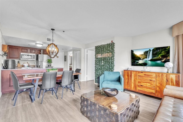 6337 Parc Corniche Dr Unit 2312, Orlando, FL 32821 - living room with a chandelier and light wood-style flooring
