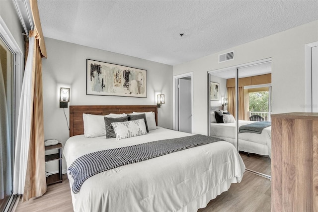 6337 Parc Corniche Dr Unit 2312, Orlando, FL 32821 - bedroom with wood finished floors, a textured ceiling, and a closet