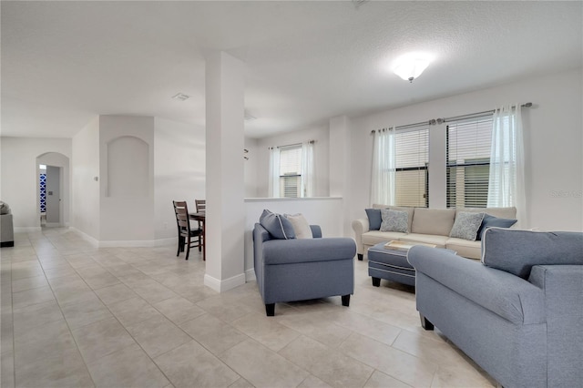 921 Costa Mesa Ln, Kissimmee, FL 34744 - living area with arched walkways, light tile patterned flooring, and baseboards