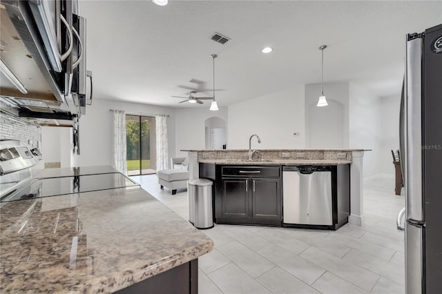 921 Costa Mesa Ln, Kissimmee, FL 34744 - kitchen with appliances with stainless steel finishes, a sink, open floor plan, light stone counters, and a ceiling fan