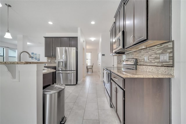 921 Costa Mesa Ln, Kissimmee, FL 34744 - kitchen with stainless steel appliances, healthy amount of natural light, decorative backsplash, light stone countertops, and recessed lighting