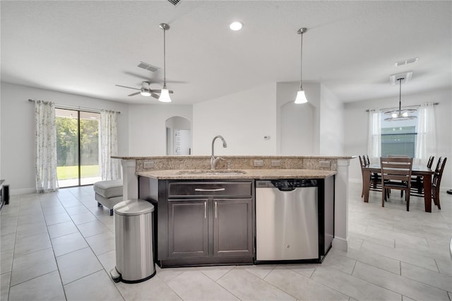 921 Costa Mesa Ln, Kissimmee, FL 34744 - kitchen with stainless steel dishwasher, a sink, light stone countertops, dark brown cabinets, and hanging light fixtures