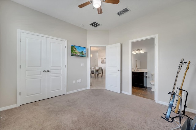 921 Costa Mesa Ln, Kissimmee, FL 34744 - carpeted bedroom featuring a closet, baseboards, connected bathroom, and ceiling fan