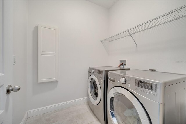921 Costa Mesa Ln, Kissimmee, FL 34744 - laundry room with baseboards, independent washer and dryer, and light tile patterned floors