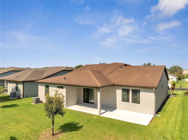921 Costa Mesa Ln, Kissimmee, FL 34744 - back of property featuring a patio, stucco siding, central AC unit, and a lawn