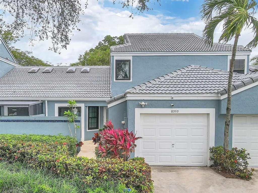 8353 Waterford Ave, Tamarac, FL 33321 - view of front of house featuring stucco siding, a tiled roof, driveway, and an attached garage