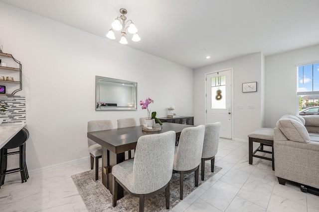 10221 Highline Crest St, Orlando, FL 32832 - dining space with light marble finish floors, a chandelier, and baseboards
