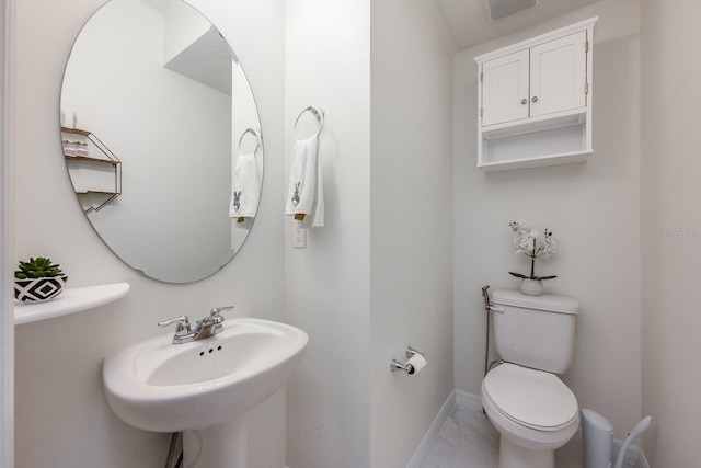 10221 Highline Crest St, Orlando, FL 32832 - bathroom with marble look tiles, toilet, baseboards, and a sink