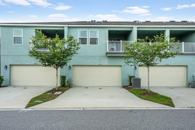 10221 Highline Crest St, Orlando, FL 32832 - view of front of home with an attached garage, cooling unit, stucco siding, and a balcony