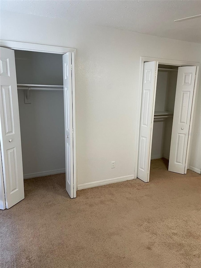 315 Wymore Rd Unit 104, Altamonte Springs, FL 32714 - unfurnished bedroom featuring carpet flooring, multiple closets, and baseboards