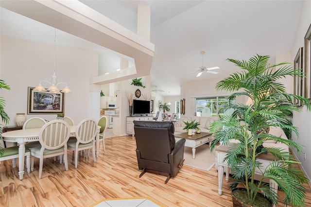 2135 Springwater Ln, Port Orange, FL 32128 - living room with light wood finished floors, a ceiling fan, a chandelier, and high vaulted ceiling