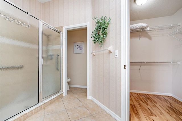2135 Springwater Ln, Port Orange, FL 32128 - full bath featuring toilet, a shower stall, a spacious closet, baseboards, and wallpapered walls
