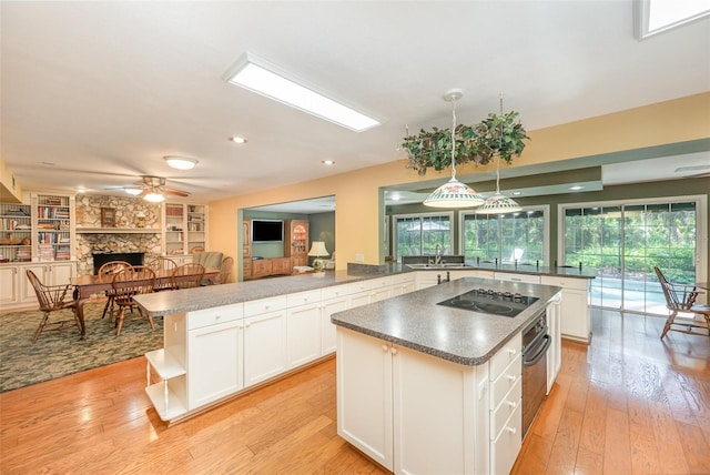 6321 Quarterhorse Cir, Cocoa, FL 32926 - kitchen with a sink, open shelves, a kitchen island, a stone fireplace, and oven