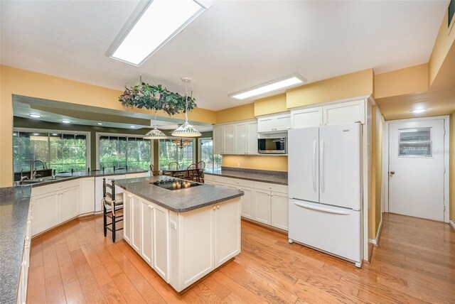 6321 Quarterhorse Cir, Cocoa, FL 32926 - kitchen featuring freestanding refrigerator, a sink, stainless steel microwave, and white cabinets