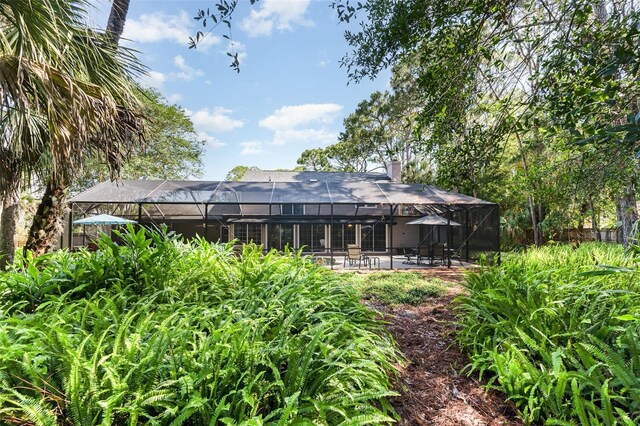 6321 Quarterhorse Cir, Cocoa, FL 32926 - rear view of property with a patio area, a lanai, and a chimney