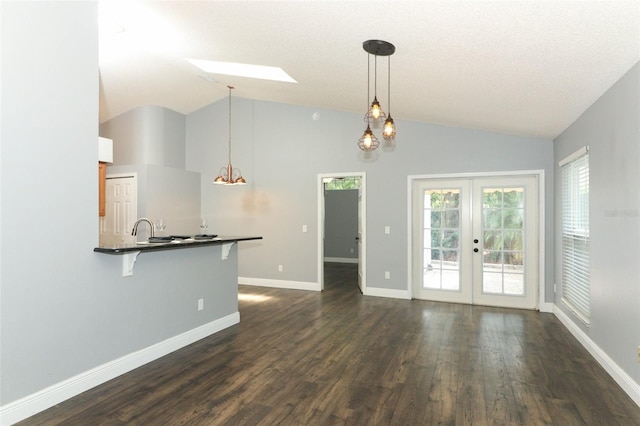 5165 Mystic Point Ct, Orlando, FL 32812 - unfurnished living room featuring vaulted ceiling, dark wood finished floors, french doors, baseboards, and a skylight