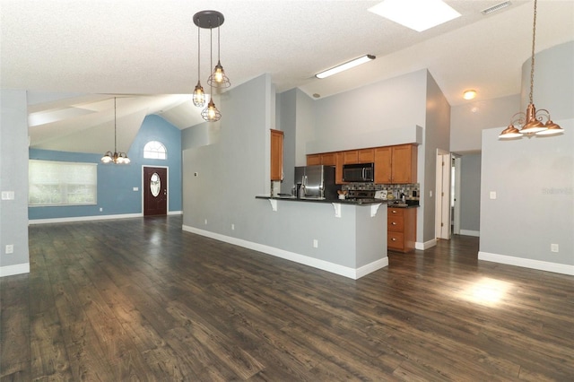 5165 Mystic Point Ct, Orlando, FL 32812 - kitchen with black microwave, dark countertops, open floor plan, brown cabinets, and stainless steel fridge