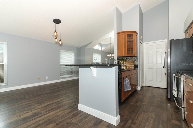 5165 Mystic Point Ct, Orlando, FL 32812 - kitchen with brown cabinets, a sink, vaulted ceiling, a kitchen breakfast bar, and a peninsula
