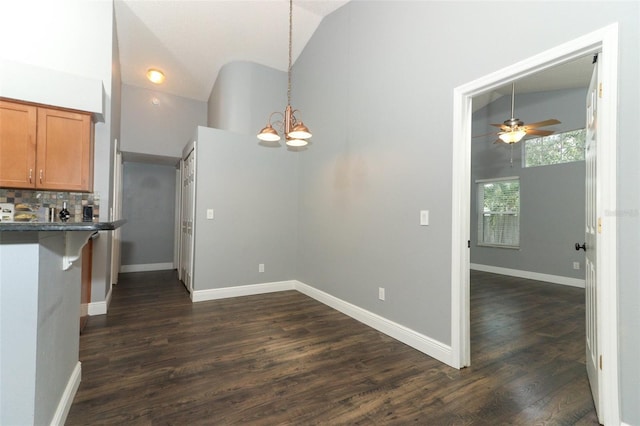 5165 Mystic Point Ct, Orlando, FL 32812 - kitchen featuring vaulted ceiling, a chandelier, brown cabinets, dark wood finished floors, and hanging light fixtures