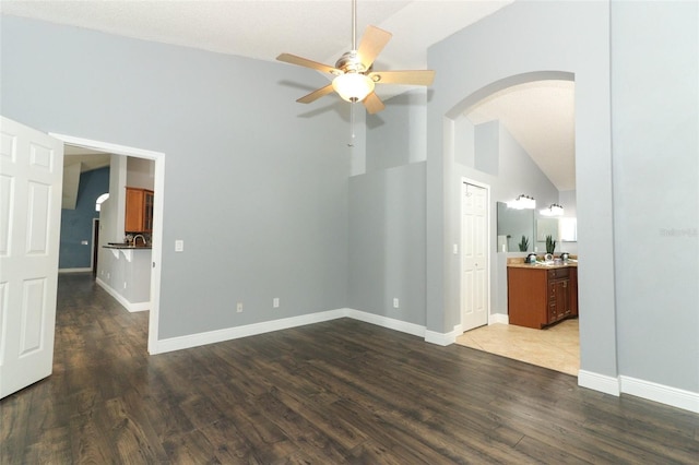 5165 Mystic Point Ct, Orlando, FL 32812 - spare room featuring ceiling fan, arched walkways, dark wood-type flooring, baseboards, and high vaulted ceiling
