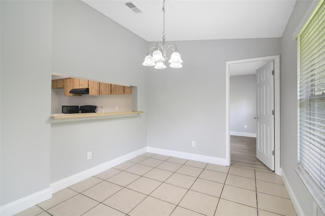 4870 S Semoran Blvd Unit 1905, Orlando, FL 32822 - kitchen featuring vaulted ceiling, light countertops, under cabinet range hood, a chandelier, and hanging light fixtures
