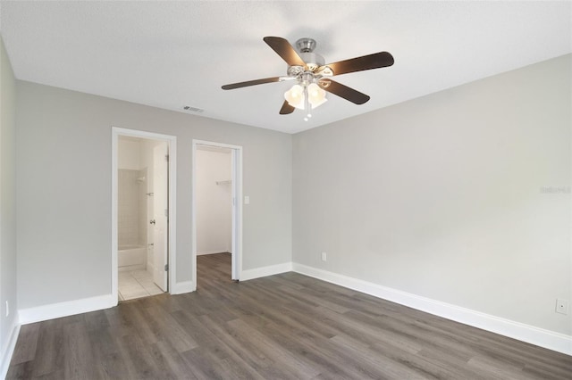 4870 S Semoran Blvd Unit 1905, Orlando, FL 32822 - unfurnished bedroom featuring wood finished floors, a walk in closet, baseboards, a closet, and a ceiling fan