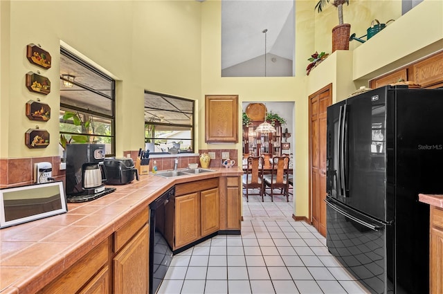 2209 Fairglenn Way, Winter Park, FL 32792 - kitchen featuring black appliances, tile counters, a sink, light tile patterned flooring, and high vaulted ceiling