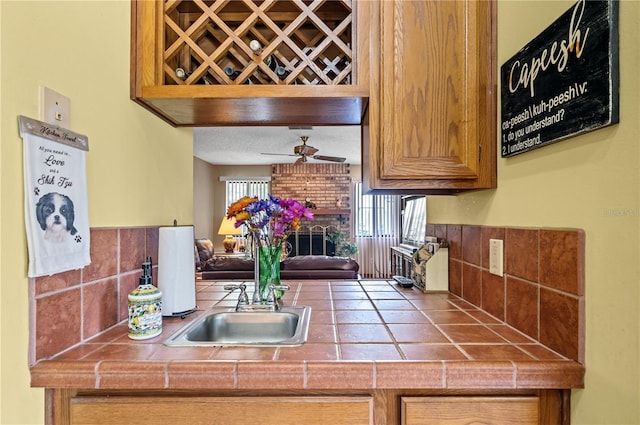 2209 Fairglenn Way, Winter Park, FL 32792 - kitchen featuring tile countertops, decorative backsplash, a ceiling fan, and a sink