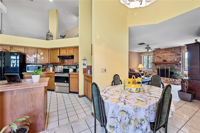 2209 Fairglenn Way, Winter Park, FL 32792 - dining room with light tile patterned floors, a ceiling fan, a towering ceiling, and a fireplace