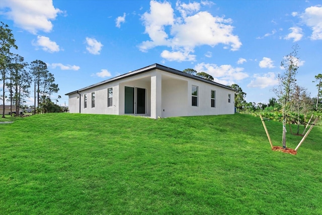 1486 Ardisia St, North Port, FL 34288 - back of property featuring stucco siding and a lawn