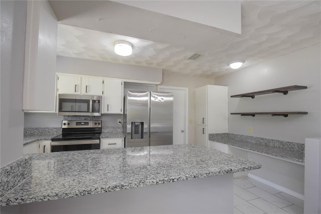 1668 Fort Smith Blvd, Deltona, FL 32725 - kitchen featuring stainless steel appliances, open shelves, light stone counters, white cabinets, and a peninsula